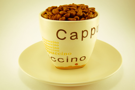 Cup full of coffee beans Isolated on white backgroundの写真素材