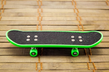 green skateboard isolated on wooden background. Stock imagesの写真素材