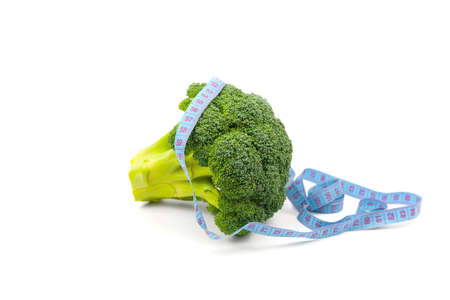 fresh brocoli with a centimeter on a white background. healthy food. eat vegetables and lose weight. Insulationの写真素材