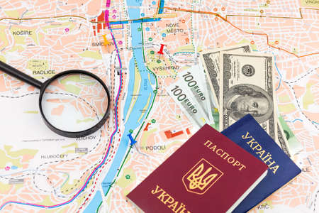 Travel arrangement with dollars, euro, two passports and magnifying glass on a map background....
