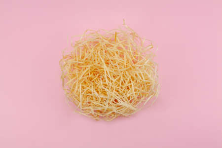 Creative flat lay concept. The love nest made of beige hay and one red heart is a symbol of love and the growth of love. Paradise pink background. Focus in the middle. Valentines or Easter idea.の写真素材