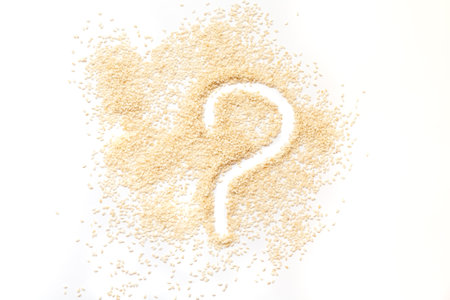 Question mark made of white sesame seeds on a white background.の写真素材