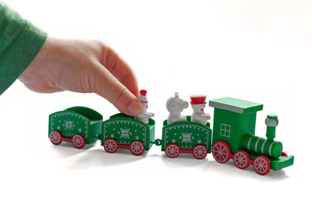 A little boy is playing with a Christmas train. white background. close-up. element for creating christmas moodの写真素材