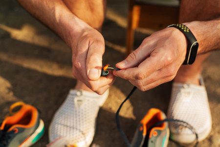A man repairs children's sneakers. Close-up of hands and sneakers. Shoemaker. Jack of all trades. Home handyman.の写真素材