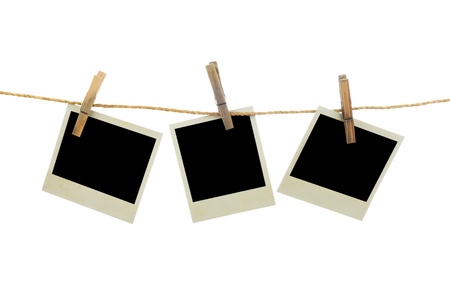 Three blank instant photos hanging on the clothesline. Isolated on white background.