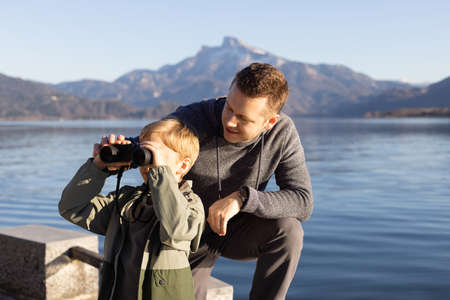 Father and son discovering the nature through binoculars. Austrian Alpsの写真素材