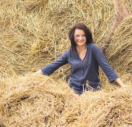 young beautiful girl on a background of haystackの写真素材