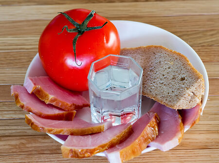 bread, meat, tomatoes and a glass of vodkaの写真素材