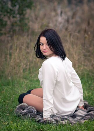 young woman sitting on the grassの写真素材