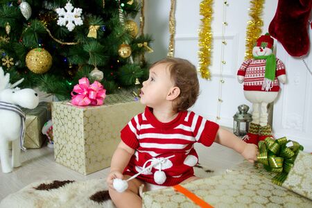 little girl with gifts under the Christmas treeの写真素材