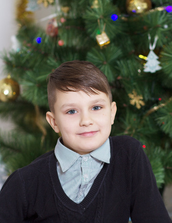 Portrait of a cute boy near Christmas treeの写真素材