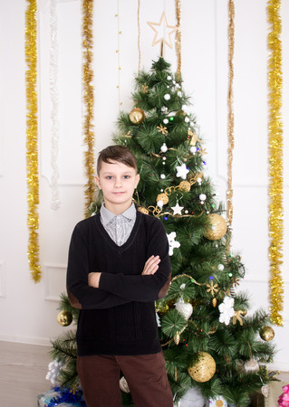 Portrait of a cute boy near Christmas treeの写真素材