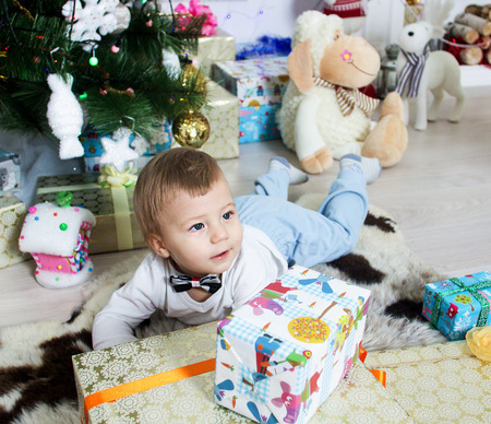 little boy near a Christmas tree with giftsの写真素材