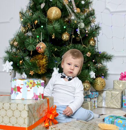 little boy near a Christmas tree with giftsの写真素材