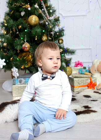 little boy near a Christmas tree with giftsの写真素材