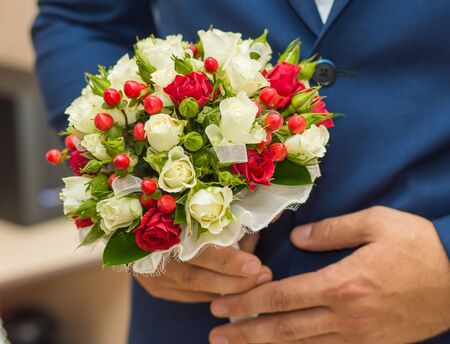 wedding bouquet in hands of the groomの写真素材