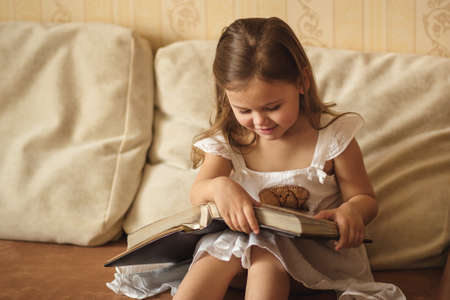 little girl looks at a family albumの写真素材