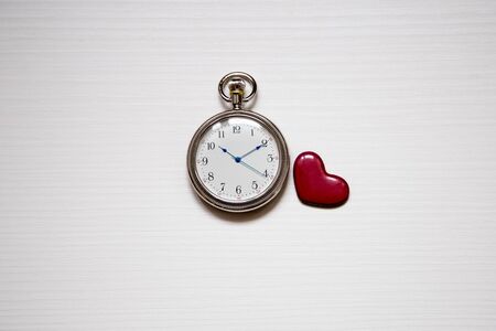 round clock and heart on a white background