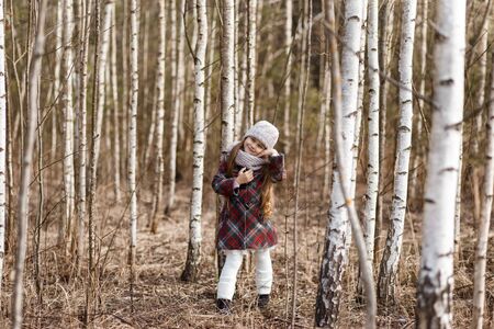 little cute girl in the birch forest in springの写真素材
