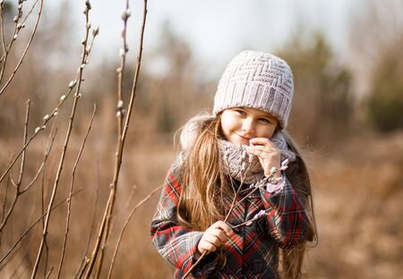 little cute girl in the spring in the forest looks at the plantsの写真素材