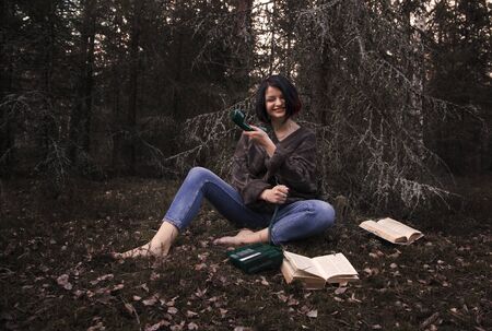 young woman is sad with a handset in natureの写真素材