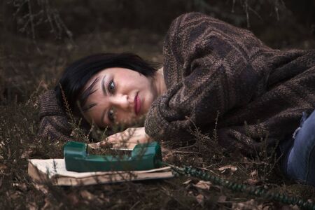 young woman is sad with a handset in natureの写真素材