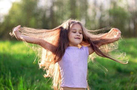 little girl dancing in nature with long hairの写真素材
