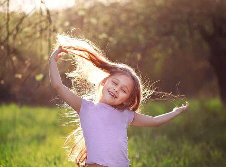 little girl dancing in nature with long hairの写真素材