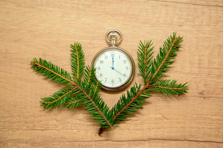clock with arrows at midnight with fir branchesの写真素材