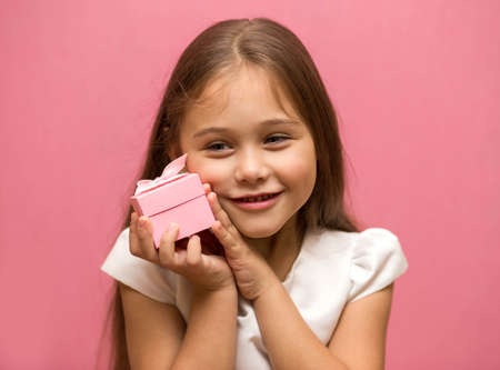 little pink gift box in the hands of a girl.の写真素材