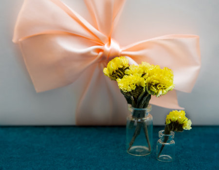 Yellow flowers in bottles against the gift box. Holiday compositeの写真素材