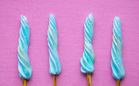 Marshmallow on a stick on a pink background.
