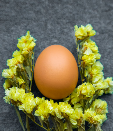Easter egg and yellow flowers on a gray background. Color trend 2021. Vertically