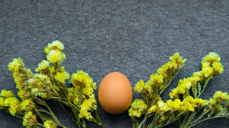 Easter egg and yellow flowers on a gray background. Copy space. Color trend 2021.の写真素材