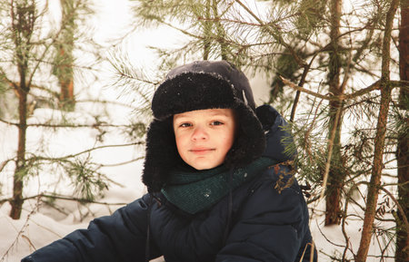 Portrait of a cute boy in a hat in winter outdoorsの写真素材