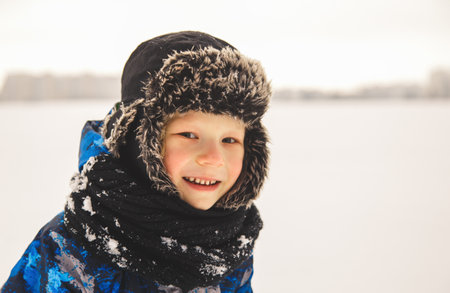 Portrait of a cute boy in a hat in winter outdoorsの写真素材