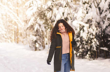 Happy pretty girl with long hair walks on a frosty winter day in the parkの写真素材