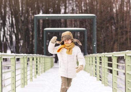 Happy boy having fun and playing in a winter parkの写真素材