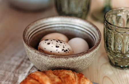 Top view close-up of chicken eggs in a white plate on a wooden table. Healthy food and natural...