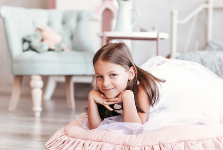Beautiful little girl plays in the light room. Portrait of a happy childの写真素材