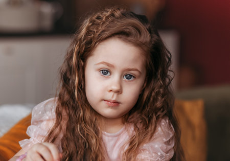 Portrait of a close-up of a little girl with long curly hair