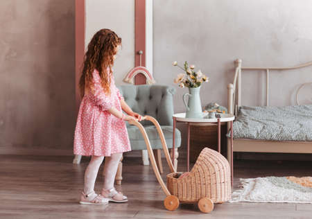 Little girl plays with toys and dolls in children's bedroomの写真素材