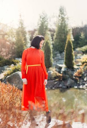 A young beautiful girl rests in nature. She's dreaming of something. A woman enjoys natureの写真素材