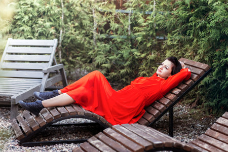A young beautiful girl rests in nature. She's dreaming of something. A woman enjoys natureの写真素材