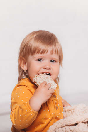 Little funny girl holds a cereal loaf in her hand