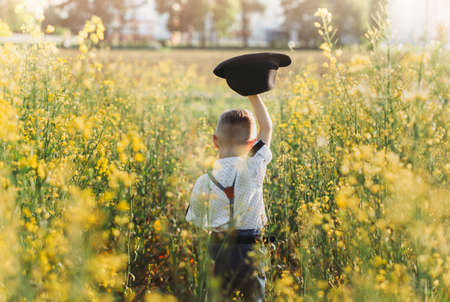 little cute boy in an oilseed rape field. Rural landscape. Verticalの写真素材