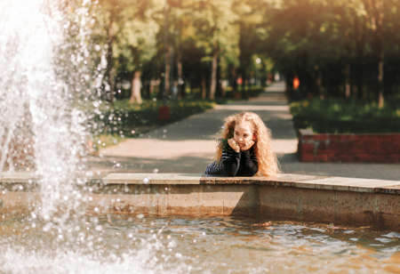 Little girl with curly hair in the park with a bouquet of wildflowersの写真素材