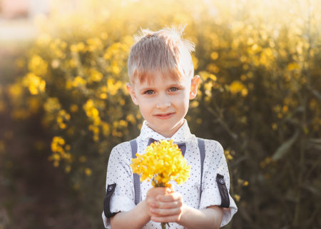 little cute boy in an oilseed rape field. Rural landscape.