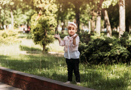 Little cute girl having fun and playing in the park in the summerの写真素材