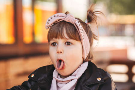 Little cute girl having fun and playing in the park in the summerの写真素材